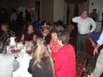 Rick Hindman, Sandy McLaughlin Goggin, Vicki Hill Mathis, Debbie Tyler Rusek sitting at table while Howard Petey Guthrie apparently does the Macarena